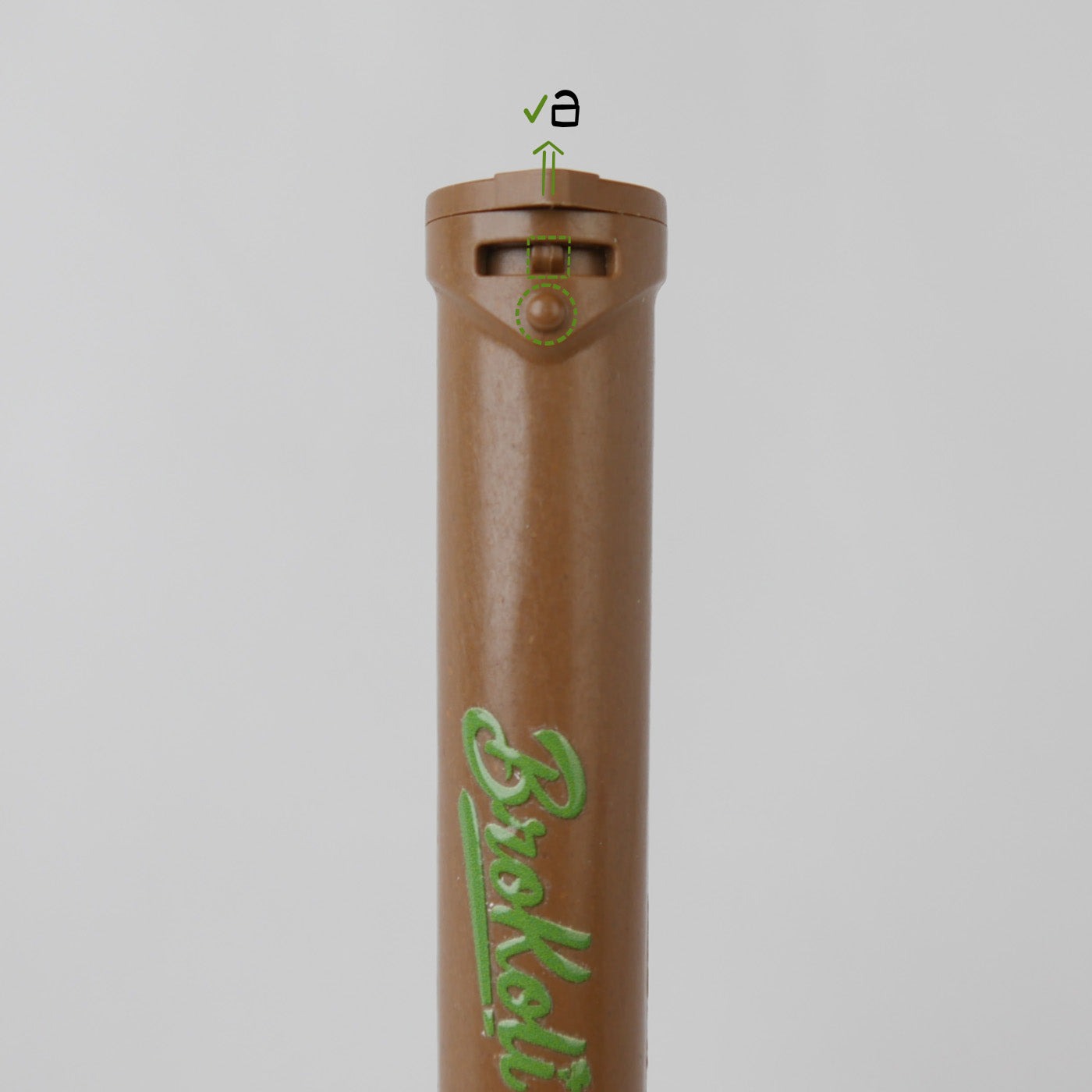 Nahaufnahme des Hemp-Based Bro2Go von BroKoli mit Fokus auf den kindersicheren Verschlussmechanismus. Der braune Deckel ist leicht angehoben, und grüne Markierungen mit Symbolen zeigen die korrekte Positionierung zum Öffnen an. Das BroKoli-Logo ist in Grün auf dem Tube aufgedruckt.