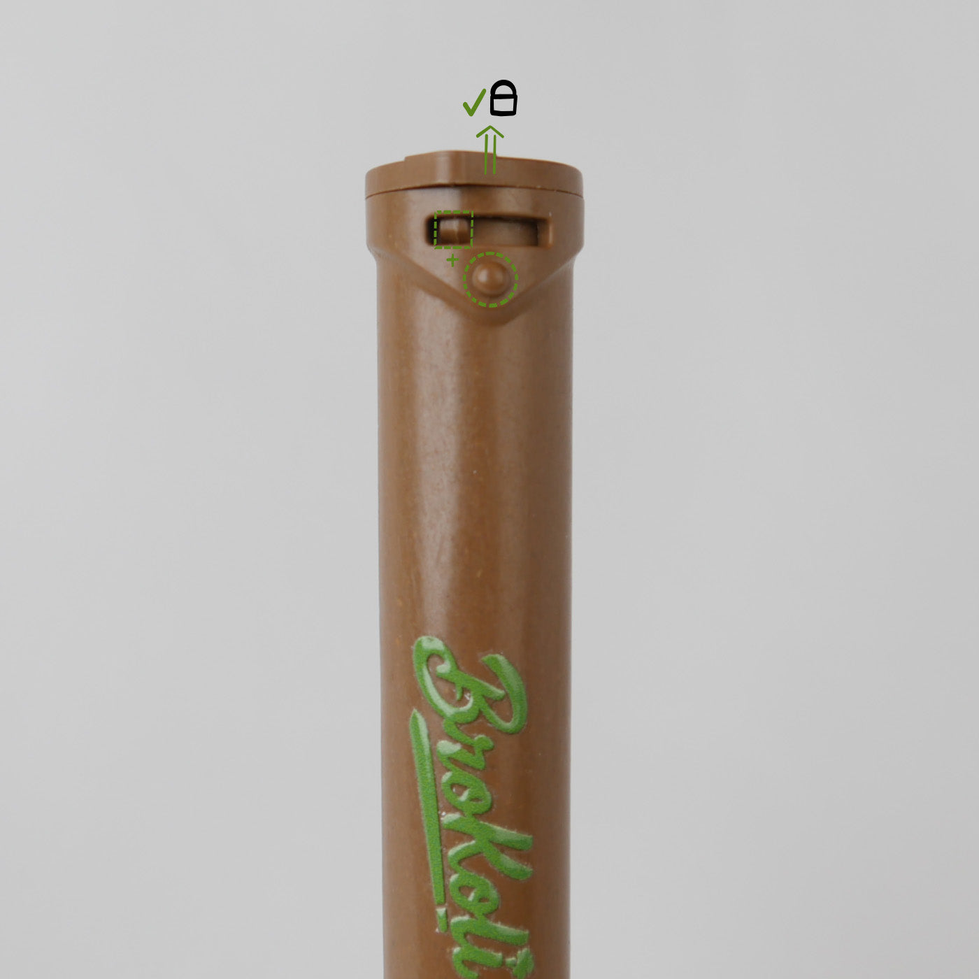 Nahaufnahme des Hemp-Based Bro2Go von BroKoli mit Fokus auf den kindersicheren Verschlussmechanismus. Der braune Deckel ist leicht angehoben, und grüne Markierungen mit Symbolen zeigen die korrekte Positionierung zum Öffnen an. Das BroKoli-Logo ist in Grün auf dem Tube aufgedruckt.