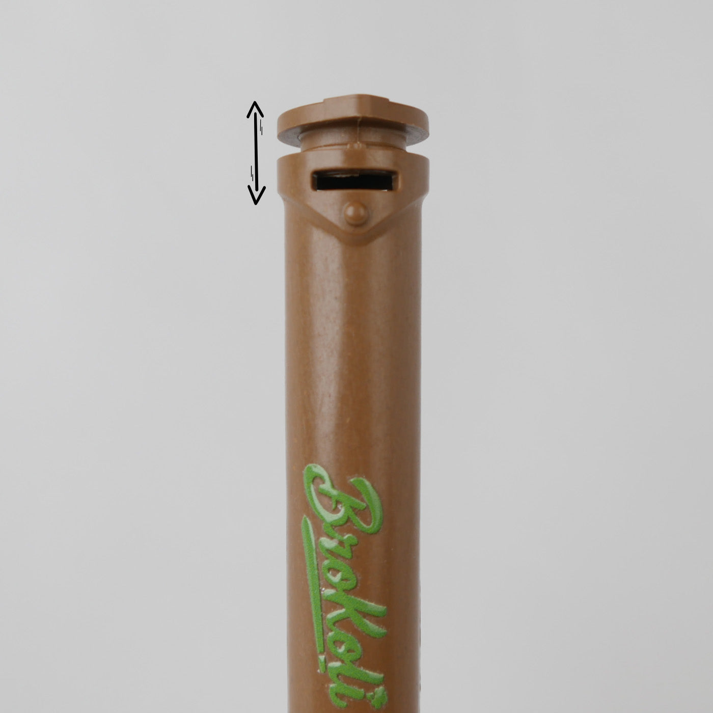 Nahaufnahme des Hemp-Based Bro2Go von BroKoli mit Fokus auf den kindersicheren Verschlussmechanismus. Der braune Deckel ist leicht angehoben, und eine schwarze Pfeilgrafik zeigt die Öffnungsbewegung an. Das BroKoli-Logo ist in Grün auf dem Tube aufgedruckt.