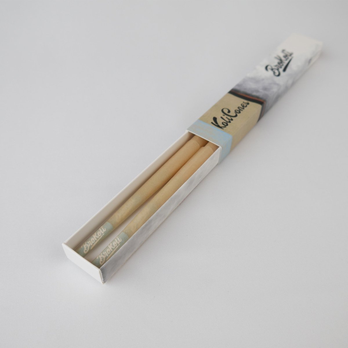6er Pack Natural Brown Colored Tip KoliCones von BroKoli in einer stilvollen Verpackung. Die warmbraunen Cones sind teilweise aus der Box herausgezogen und zeigen das BroKoli-Logo auf den Blue Tips.