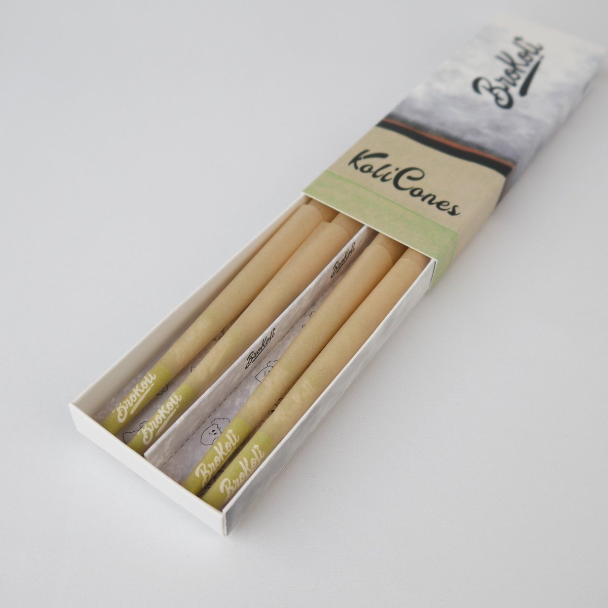 12er Pack Natural Brown Colored Tip KoliCones von BroKoli in einer stilvollen Verpackung. Die warmbraunen Cones sind teilweise aus der Box herausgezogen und zeigen das BroKoli-Logo auf den Green Tips.