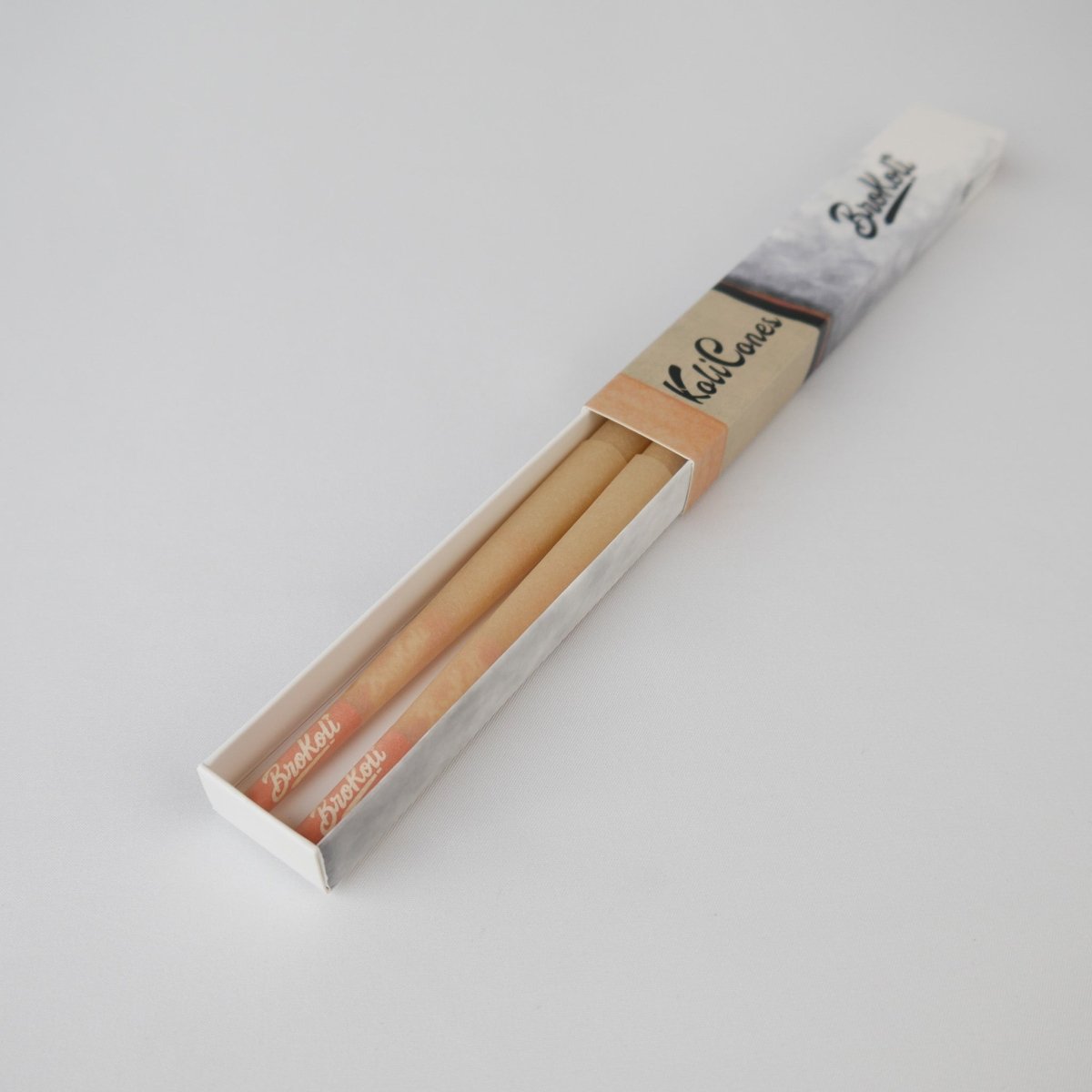 6er Pack Natural Brown Colored Tip KoliCones von BroKoli in einer stilvollen Verpackung. Die warmbraunen Cones sind teilweise aus der Box herausgezogen und zeigen das BroKoli-Logo auf den Orange Tips.
