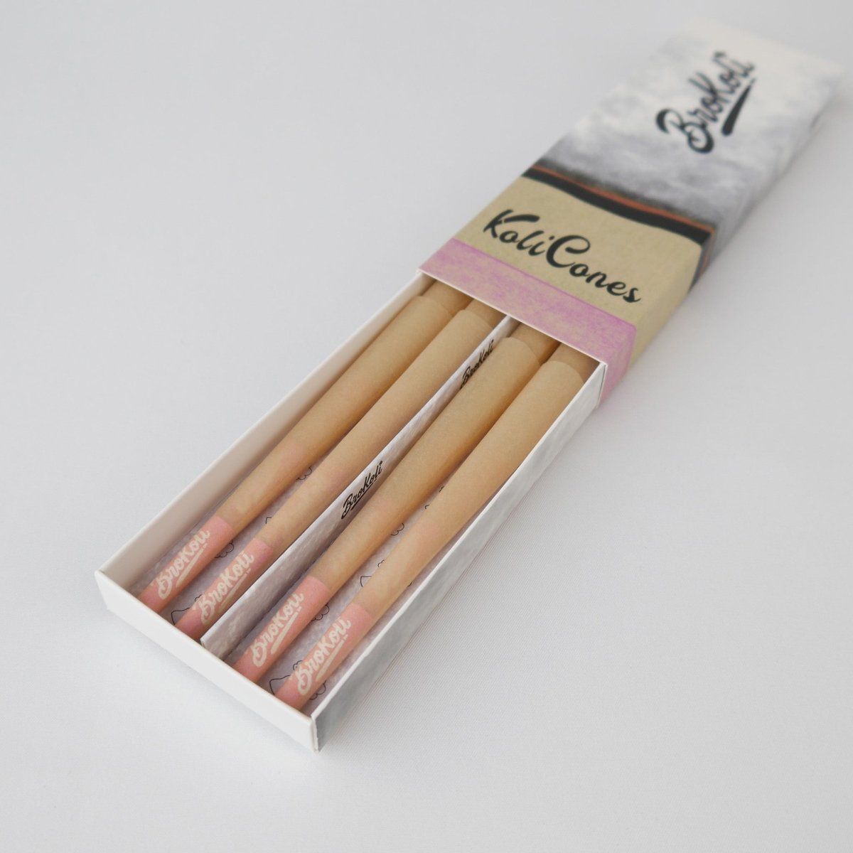 12er Pack Natural Brown Colored Tip KoliCones von BroKoli in einer stilvollen Verpackung. Die warmbraunen Cones sind teilweise aus der Box herausgezogen und zeigen das BroKoli-Logo auf den Pink Tips.