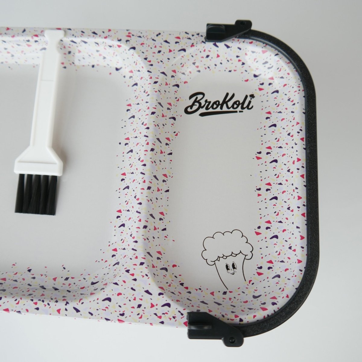Nahaufnahme des KoliTray im Terrazzo-Design mit BroKoli-Logo, BroKoli Maskottchen und Reinigungsbürste – funktionales Rolling Tray mit stilvollem Look.