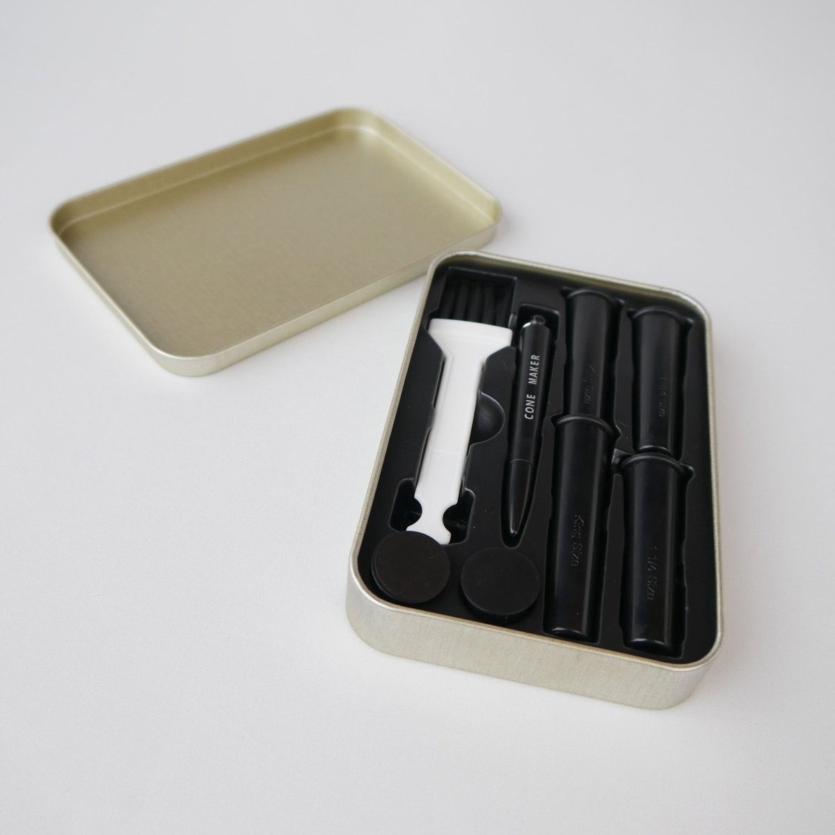 Geöffnete Zubehörbox des KoliTray mit Cone-Fillern, Reinigungsbürste und Cone-Maker – praktisches Set für das einfache Befüllen von Joints.