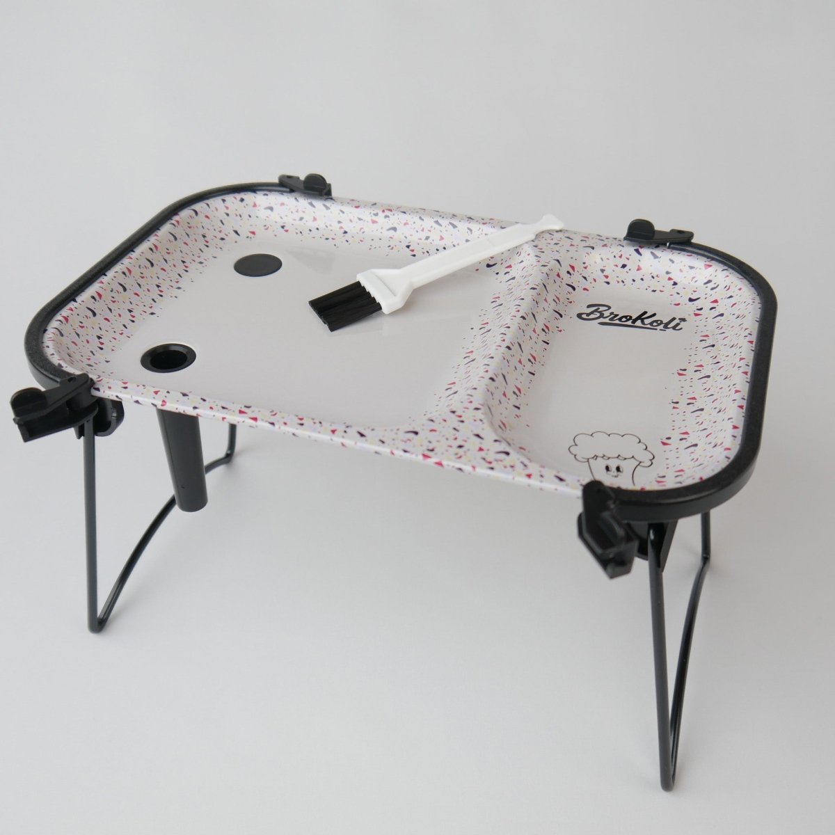 KoliTray im Terrazzo-Design mit ausgeklappten Beinen, Cone-Öffnungen und Reinigungsbürste – tragbares Rolling Tray mit integriertem Befüllsystem.