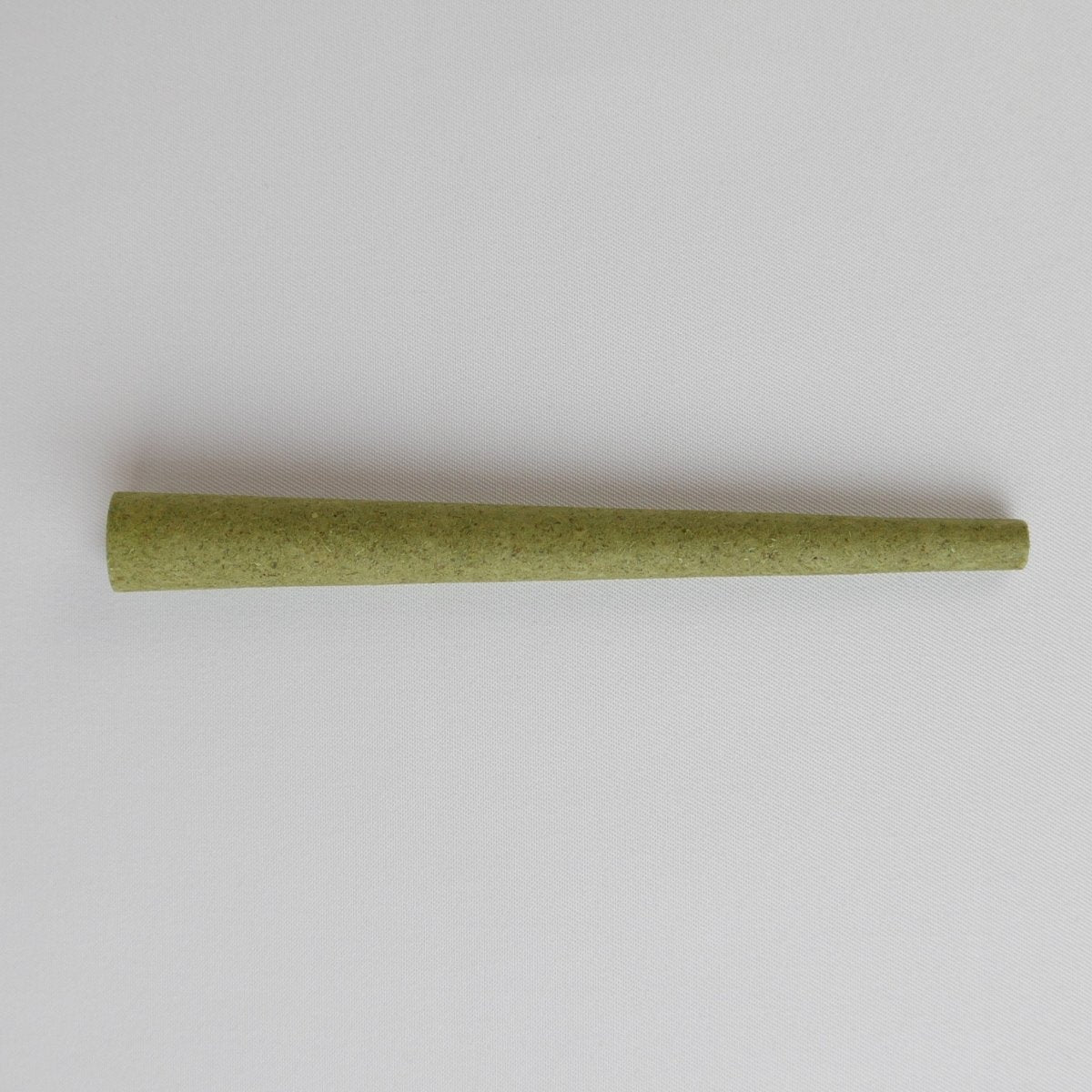 Ein Green Hemp KoliCone von BroKoli auf hellem Stoffhintergrund. Die natürliche grüne Farbe unterstreicht das organische Material, während die feine Struktur für eine hochwertige Verarbeitung spricht.