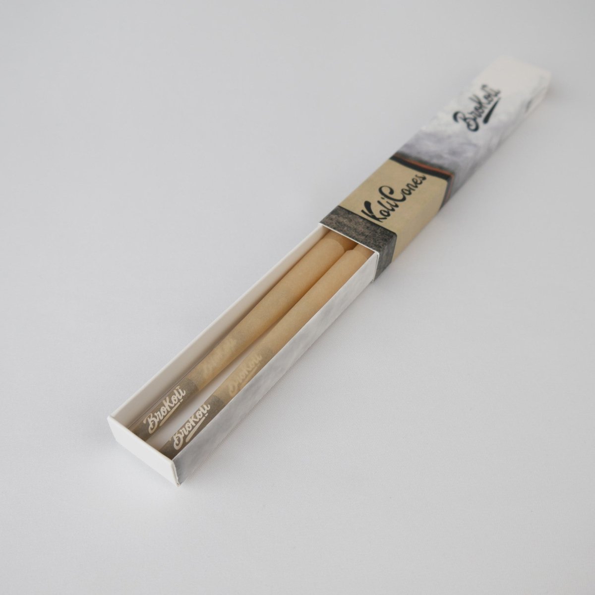 6er Pack Natural Brown Colored Tip KoliCones von BroKoli in einer stilvollen Verpackung. Die warmbraunen Cones sind teilweise aus der Box herausgezogen und zeigen das BroKoli-Logo auf den Black Tips.