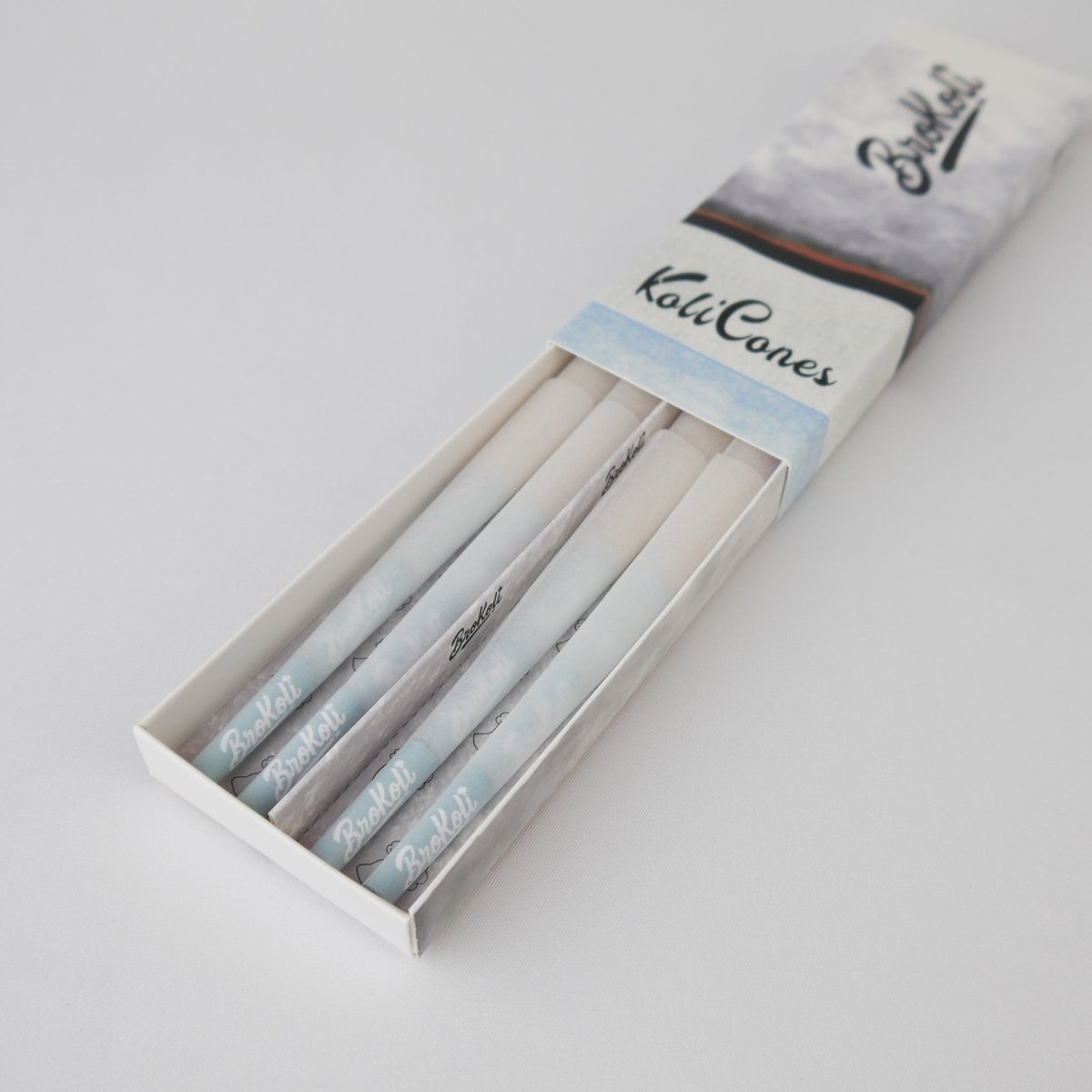 12er Pack Refined White Colored Tip KoliCones von BroKoli in einer stilvollen Verpackung. Die hellen, veredelten Cones sind teilweise aus der Box herausgezogen und zeigen das BroKoli-Logo auf den Blue Tips.